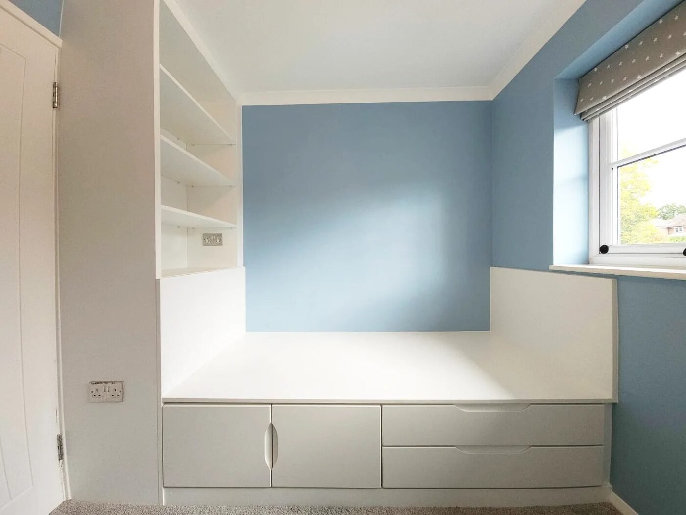 Bespoke storage bed with handleless drawers and cupboards built in