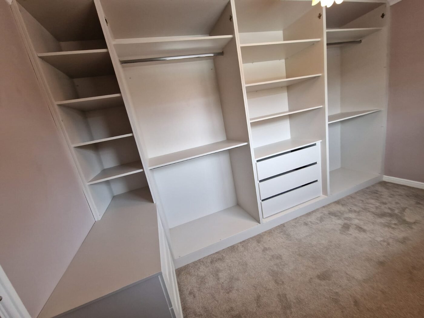 Walk-in wardrobe with open shelving, rails and drawers under the eaves in Warrington