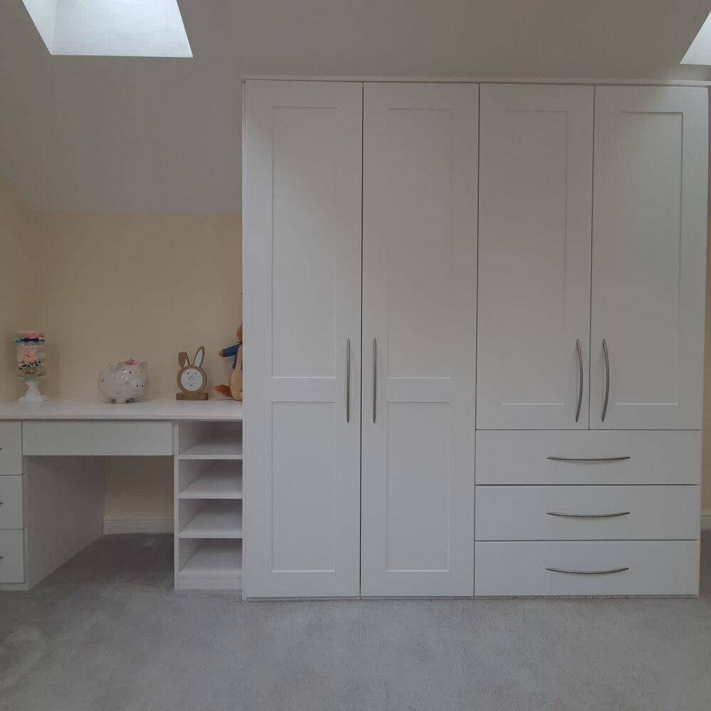 White fitted wardrobes fitted around a doorway and eaves