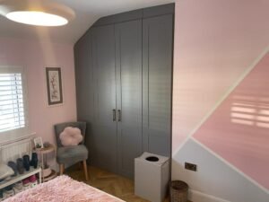 Bespoke fitted wardrobes, made to measure and installed to maximise space in a room with an angled corner ceiling.