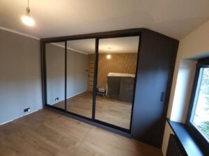 Fitted sliding wardrobe with green doors and dressing table by WOW Wardrobes
